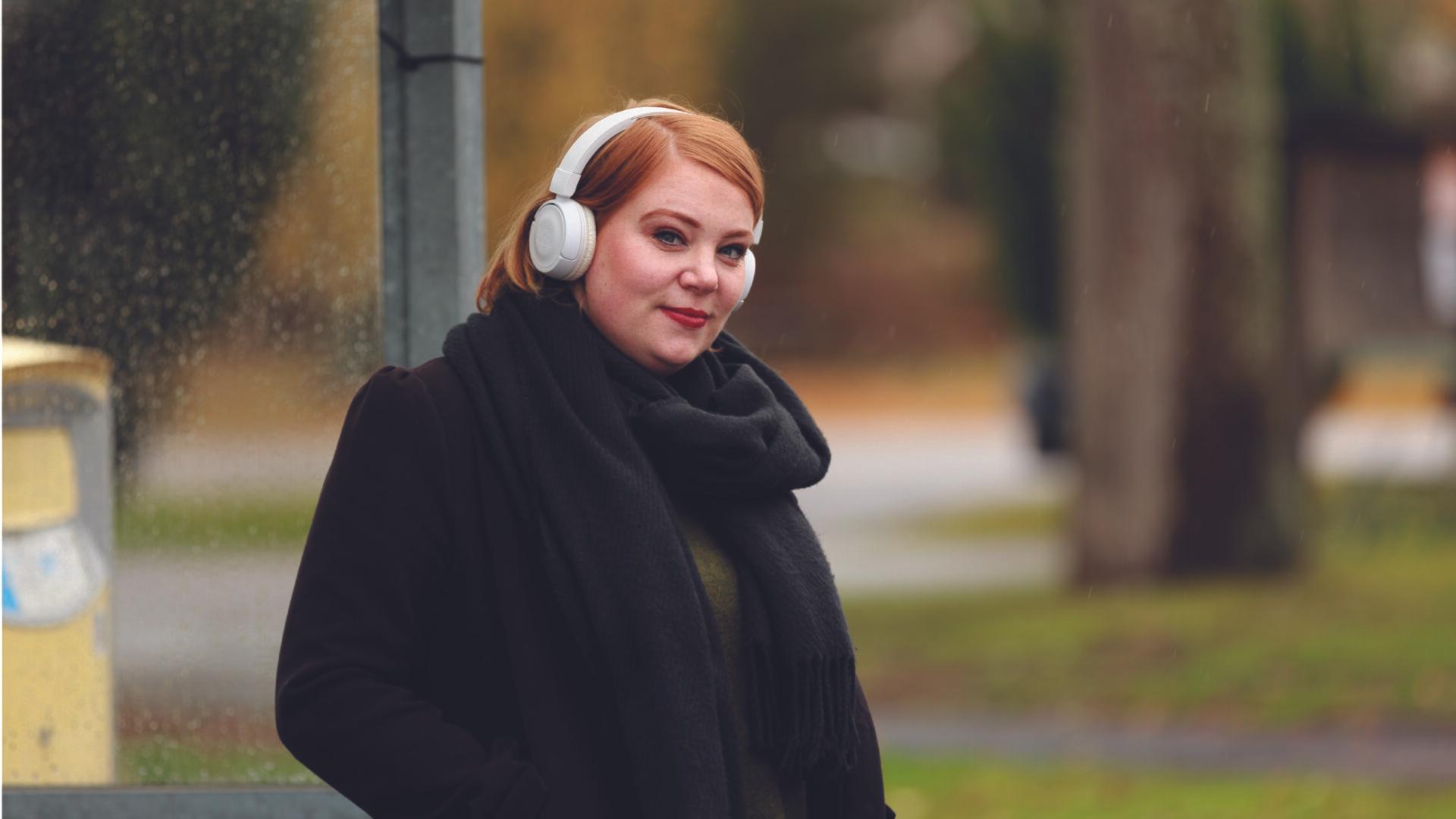 Kvinna som lyssnar på musik i hörlurar.