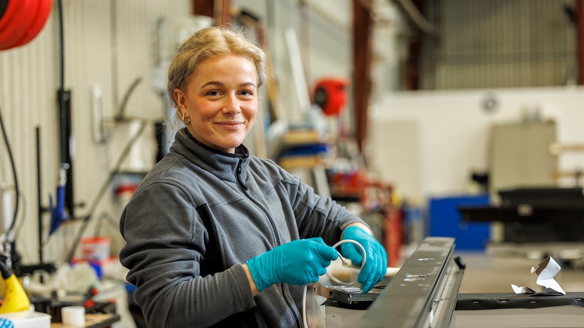 Ung kvinna som arbetar i en fabrik eller verkstad