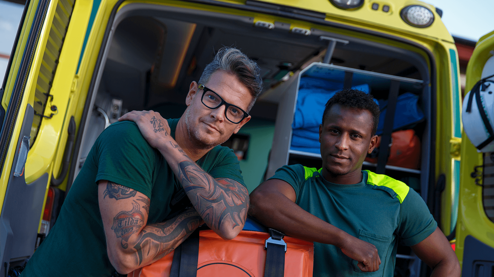 Två ambulansförare framför sitt fordon