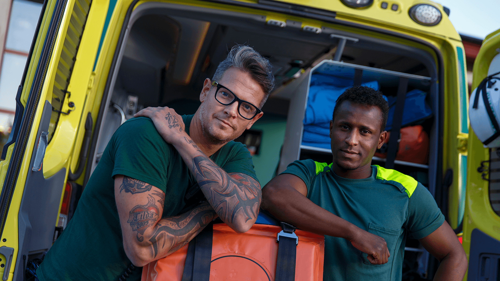 Två ambulansförare framför sitt fordon
