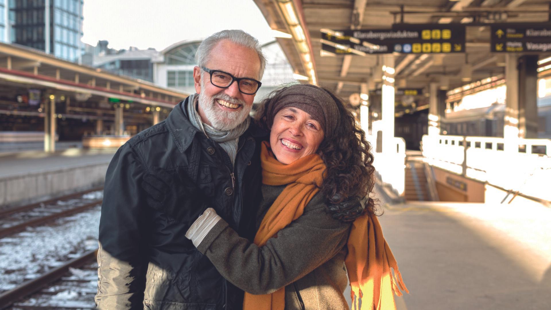 Glatt äldre par på tågstation