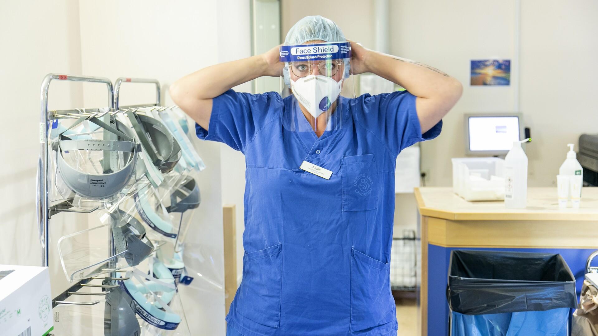 Undersköterska med munskydd arbetar under pandemin