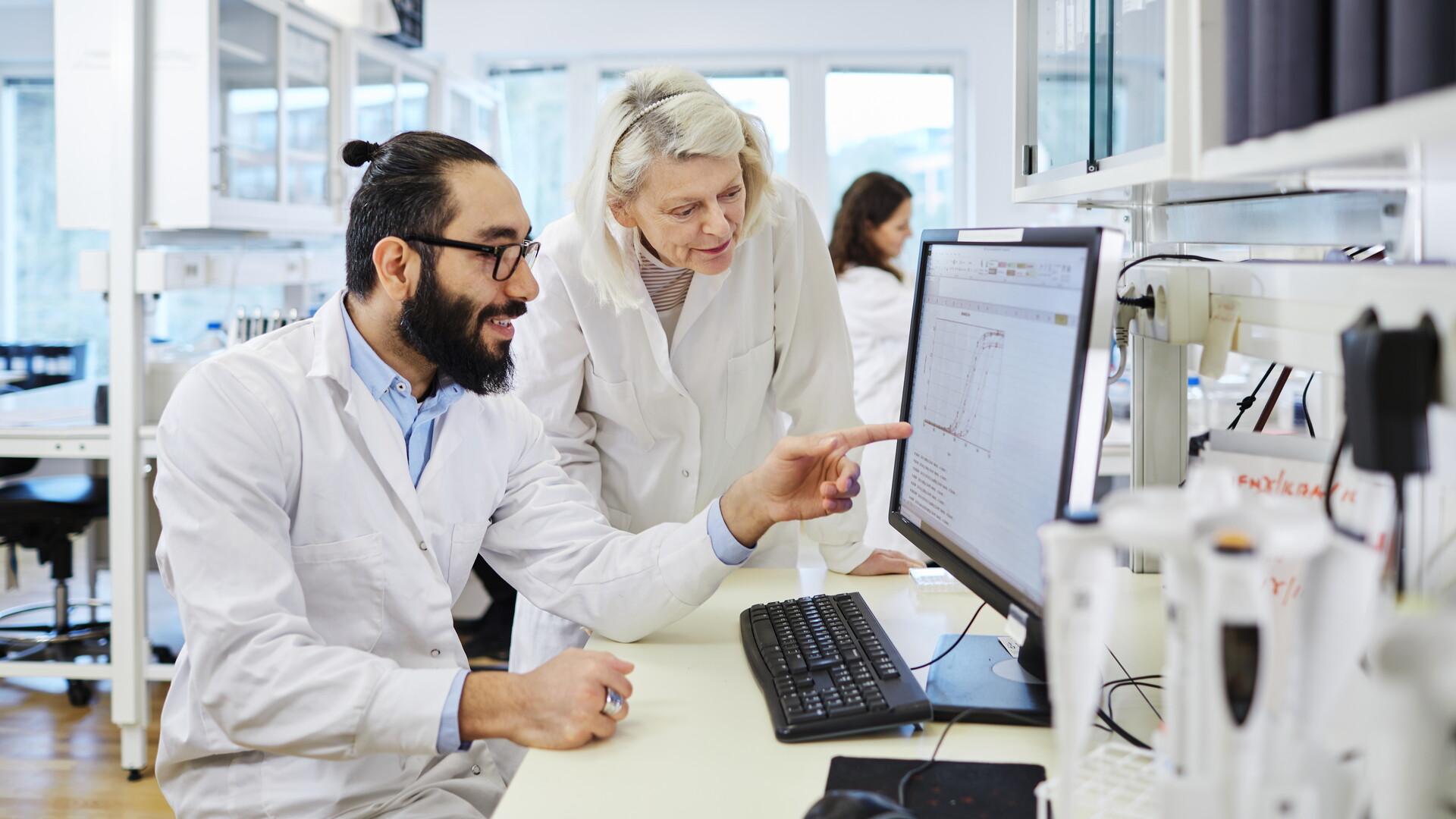 Bild på man och kvinna vid dator i ett laboratorium.