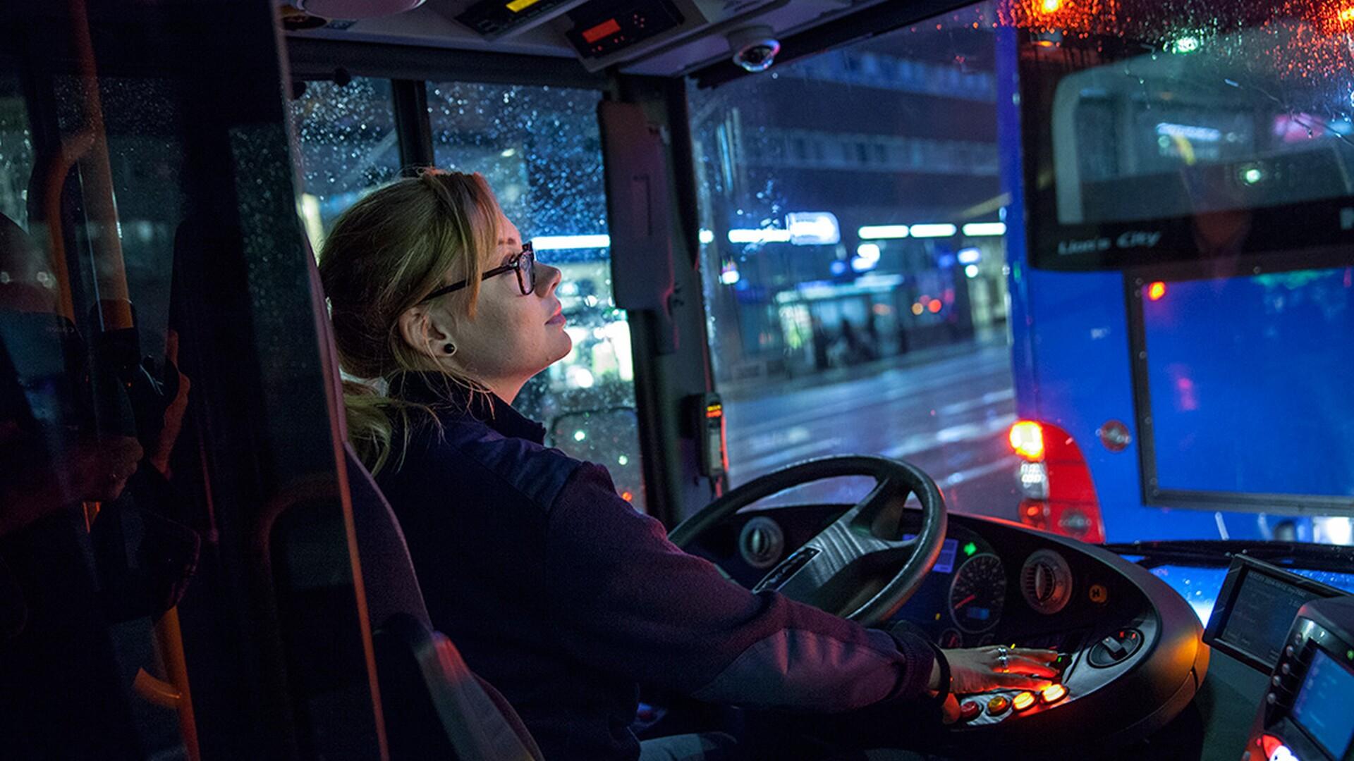 Kvinnlig bussförare i förarsätet