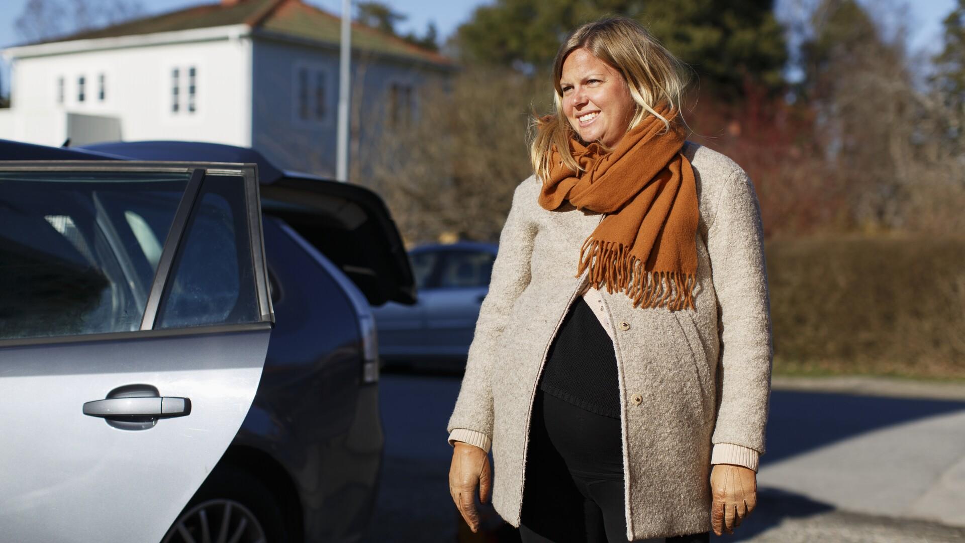 Gravid kvinna bredvid en bil