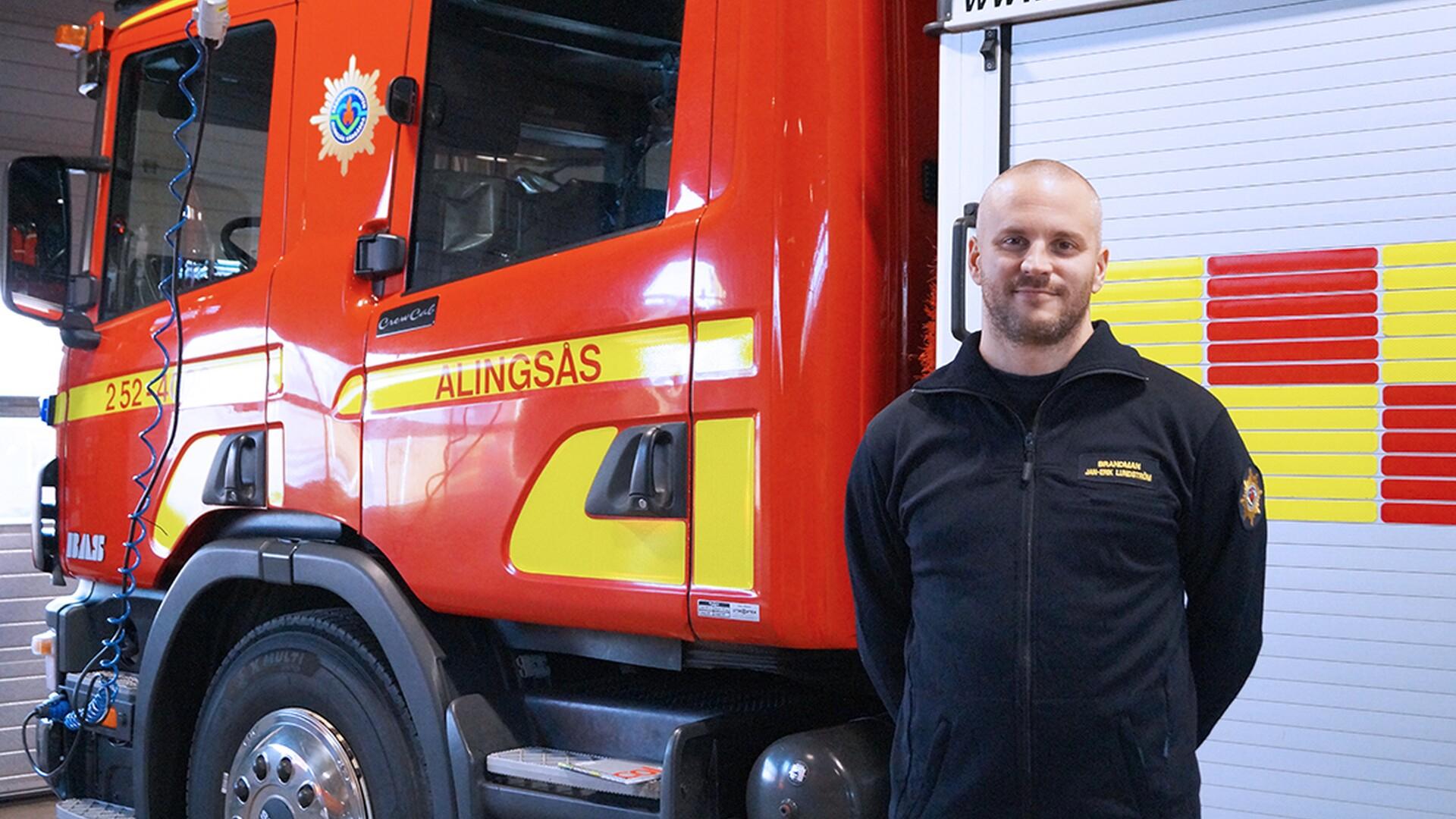 Jan-Erik Lundström är brandman och förtroendevald i Alingsås. Står framför brandbil.