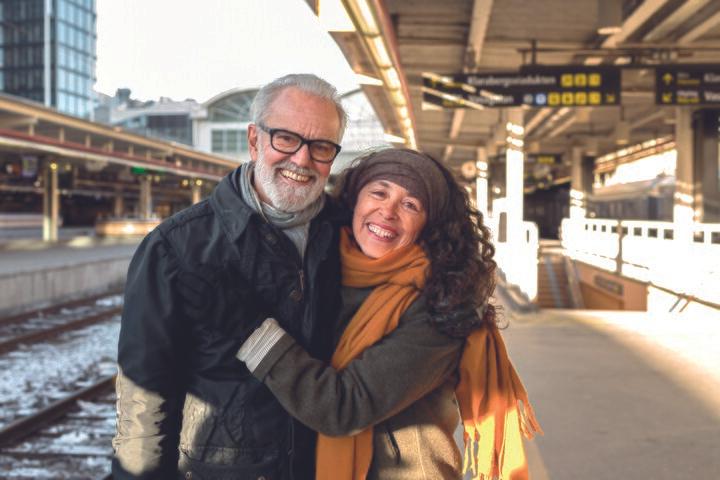 Glatt äldre par på tågstation