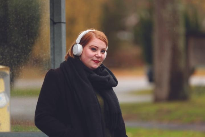 Kvinna som lyssnar på musik i hörlurar.