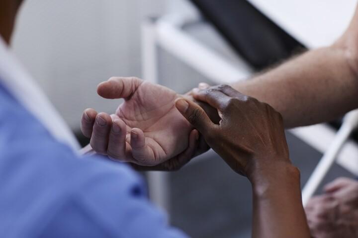 Händer som möts i vårdmiljö.