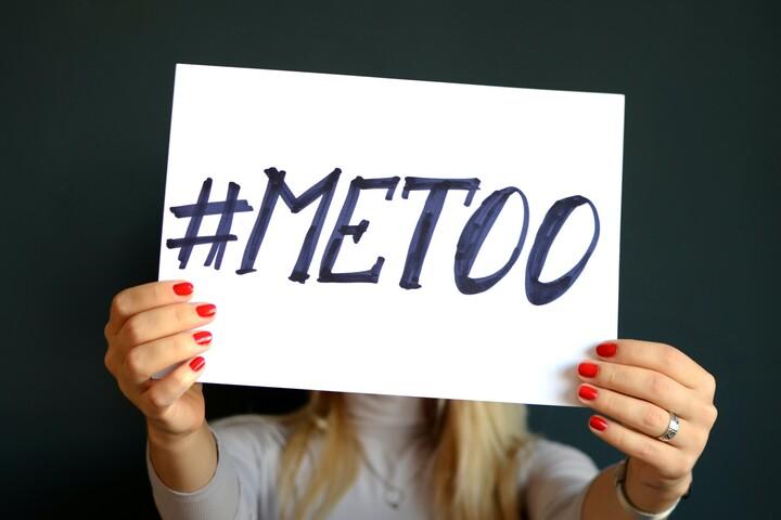 Kvinna håller upp skylt med texten #MeToo.