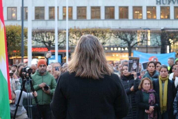 Malin Ragnegårds på en scen inför deltagare på demonstration.